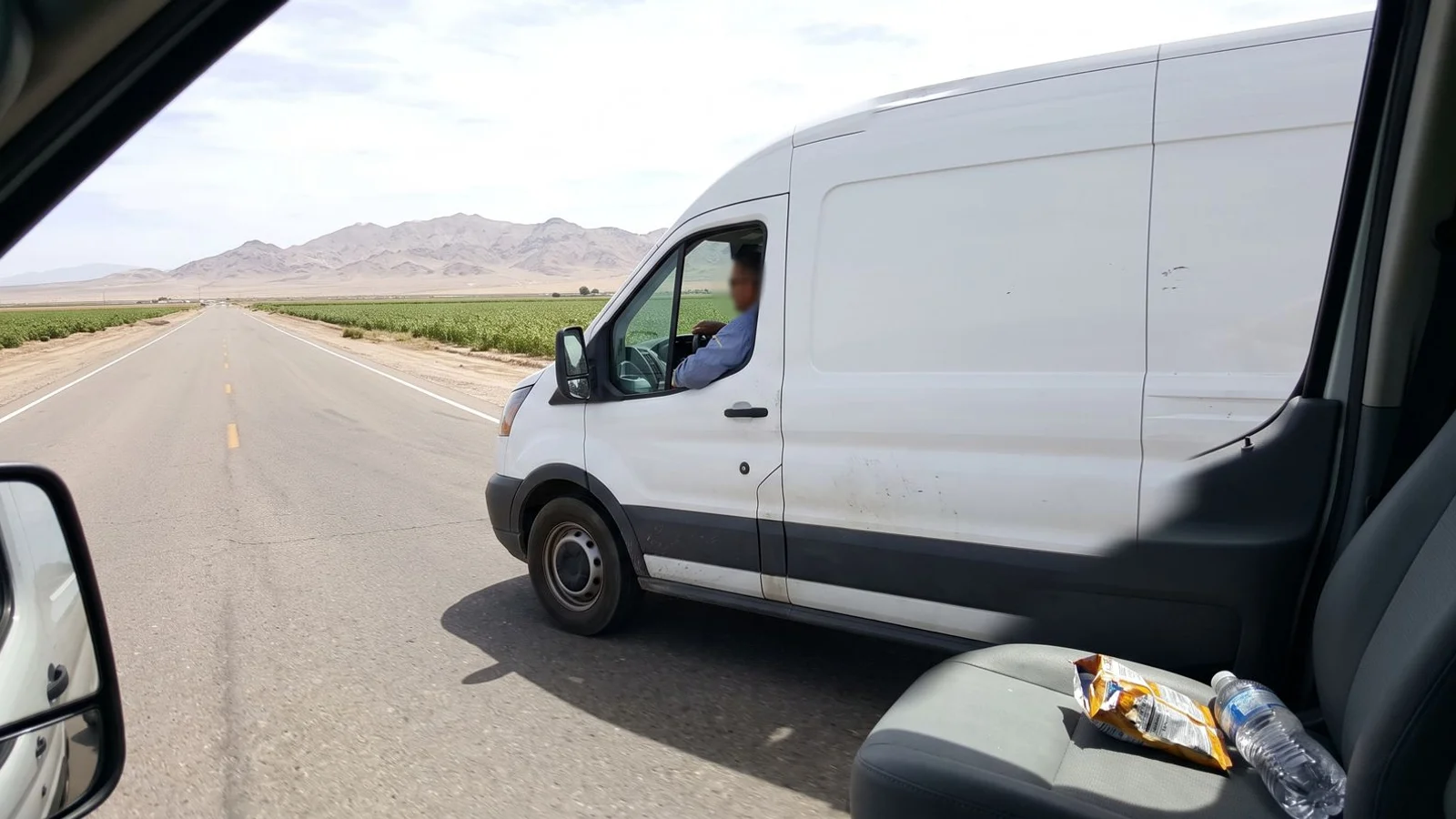 Plumbing service van on a long straight Imperial County road with irrigated fields behind it